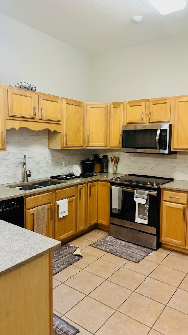 kitchen featuring decorative backsplash, stainless steel appliances, light countertops, a sink, and light tile patterned flooring