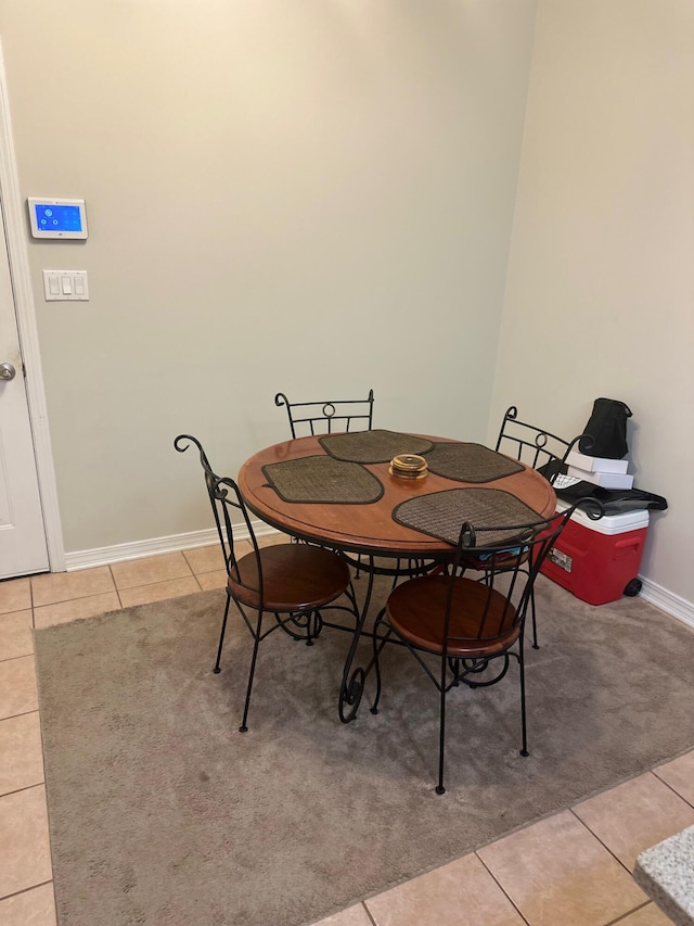 dining space featuring light tile patterned floors and baseboards