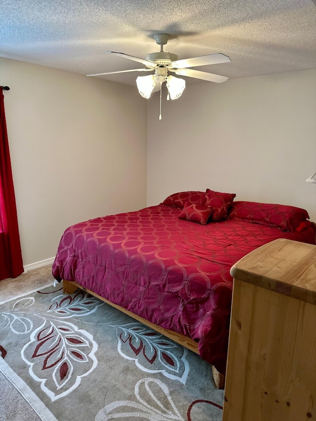 bedroom featuring a textured ceiling, a ceiling fan, and carpet floors