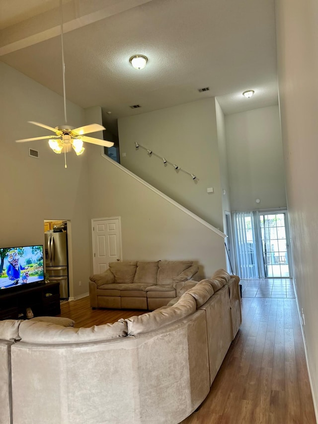 living area featuring visible vents, high vaulted ceiling, wood finished floors, and ceiling fan