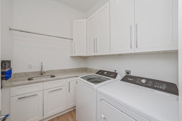 65 Horseshoe Cir, Miramar Beach, FL 32550 - laundry room with light wood-style floors, a sink, cabinet space, and washer and clothes dryer
