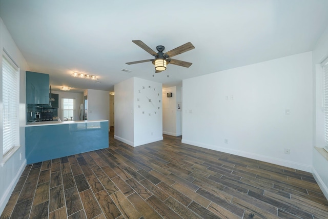 unfurnished living room featuring dark wood-style floors, visible vents, a ceiling fan, and baseboards