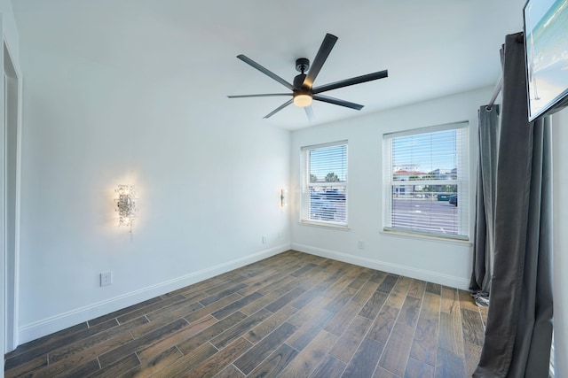 empty room featuring dark wood finished floors, baseboards, and ceiling fan