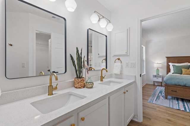 full bathroom featuring a sink, double vanity, wood finished floors, and visible vents