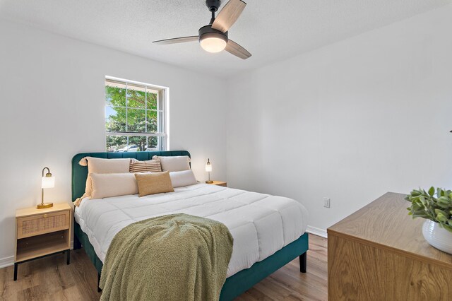 bedroom featuring baseboards, ceiling fan, and wood finished floors