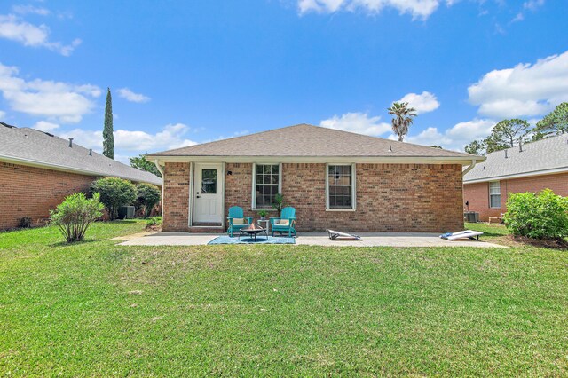 back of house featuring central AC unit, a yard, a patio area, and brick siding