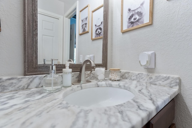 bathroom with vanity and a textured wall