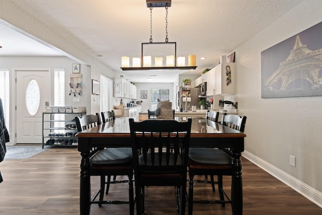 dining area with baseboards and dark wood finished floors