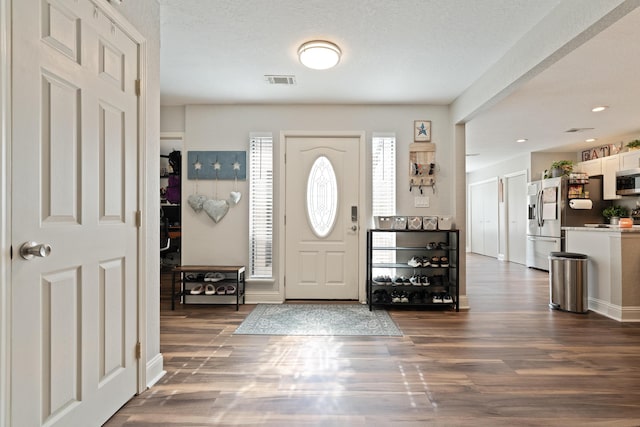 entrance foyer featuring dark wood-style flooring and visible vents