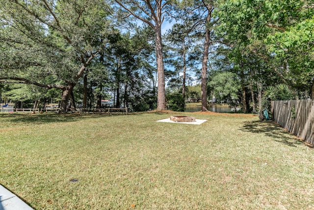 view of yard with a fire pit and fence