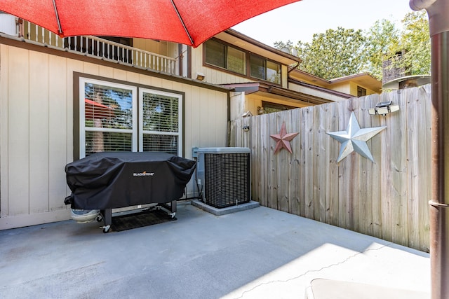 view of patio featuring central AC unit, a grill, and fence