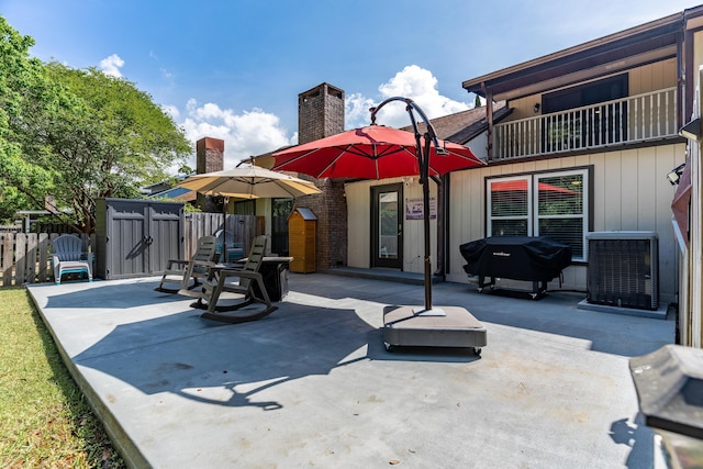 back of property with fence, a patio area, a chimney, and central AC