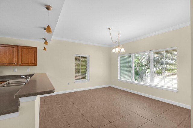 113 SE Brooks St Unit 201, Fort Walton Beach, FL 32548 - kitchen featuring brown cabinetry, ornamental molding, light tile patterned flooring, and dark countertops