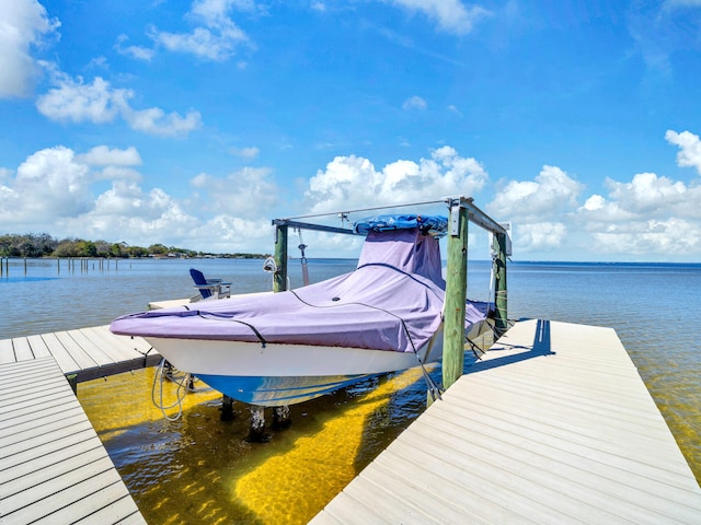 view of dock with boat lift and a water view