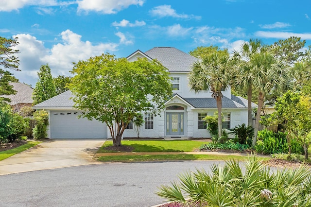 597 Avalon Blvd, Miramar Beach, FL 32550 - colonial house featuring fence, roof with shingles, a front lawn, a garage, and concrete driveway