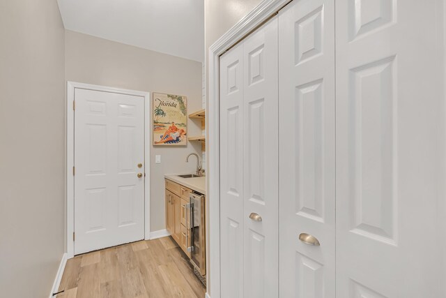 597 Avalon Blvd, Miramar Beach, FL 32550 - interior space featuring a sink, baseboards, light wood finished floors, wine cooler, and indoor bar
