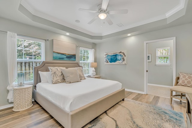 597 Avalon Blvd, Miramar Beach, FL 32550 - bedroom with crown molding, a tray ceiling, multiple windows, and light wood-style flooring