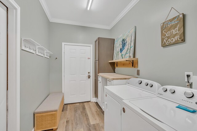 597 Avalon Blvd, Miramar Beach, FL 32550 - laundry area with crown molding, separate washer and dryer, light wood-type flooring, and cabinet space