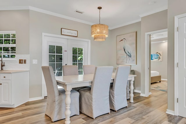 597 Avalon Blvd, Miramar Beach, FL 32550 - dining room featuring crown molding, visible vents, light wood finished floors, and a wealth of natural light