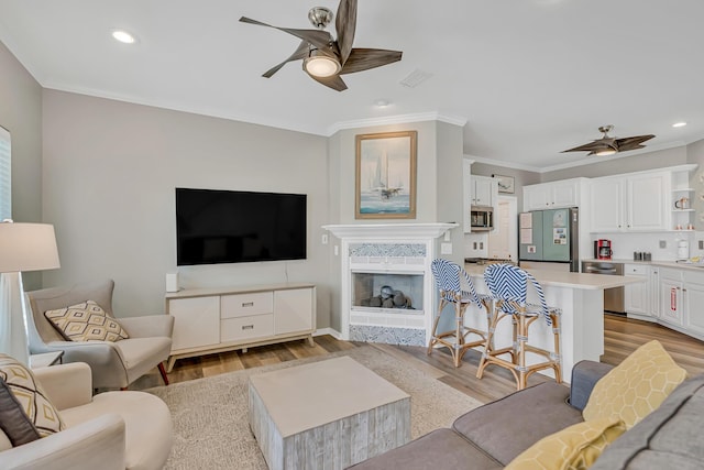597 Avalon Blvd, Miramar Beach, FL 32550 - living room with recessed lighting, ornamental molding, a ceiling fan, and light wood-type flooring