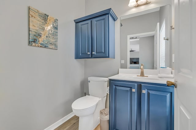 597 Avalon Blvd, Miramar Beach, FL 32550 - half bathroom with toilet, baseboards, wood finished floors, and vanity