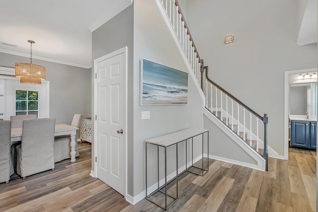 597 Avalon Blvd, Miramar Beach, FL 32550 - interior space with crown molding, baseboards, an inviting chandelier, stairs, and light wood-style flooring