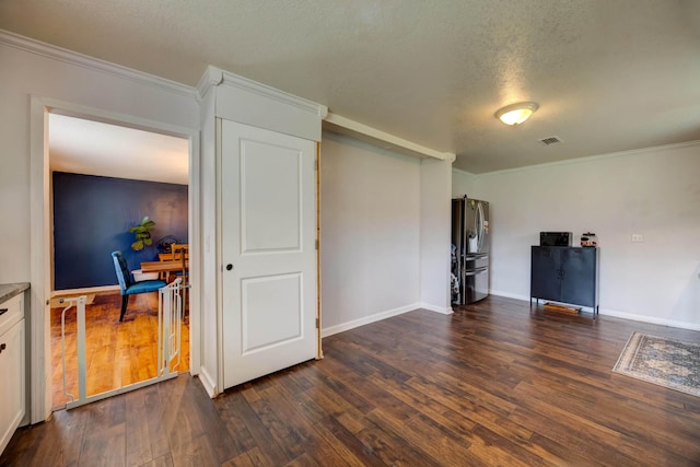 unfurnished living room featuring a textured ceiling, visible vents, crown molding, and dark wood-style floors