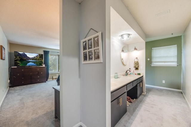 bathroom with double vanity, a sink, and baseboards