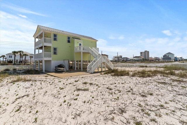 8054 Gulf Blvd, Navarre, FL 32566 - rear view of house with a standing seam roof, metal roof, a balcony, a patio, and stairs