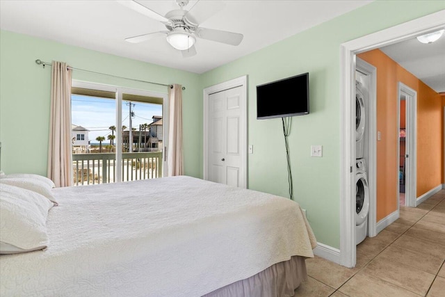 8054 Gulf Blvd, Navarre, FL 32566 - bedroom with a ceiling fan, stacked washer / dryer, light tile patterned floors, baseboards, and access to outside