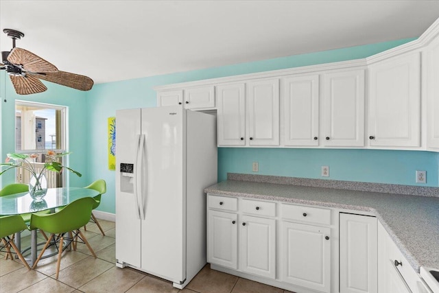 8054 Gulf Blvd, Navarre, FL 32566 - kitchen with light tile patterned flooring, white refrigerator with ice dispenser, light countertops, white cabinets, and a ceiling fan