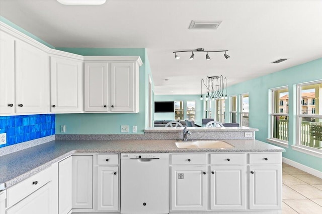 8054 Gulf Blvd, Navarre, FL 32566 - kitchen featuring visible vents, dishwasher, a sink, a peninsula, and white cabinetry