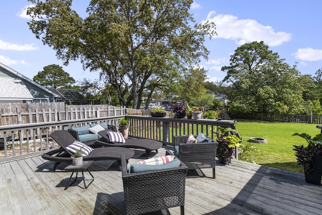 wooden deck with an outdoor hangout area, a yard, and a fenced backyard