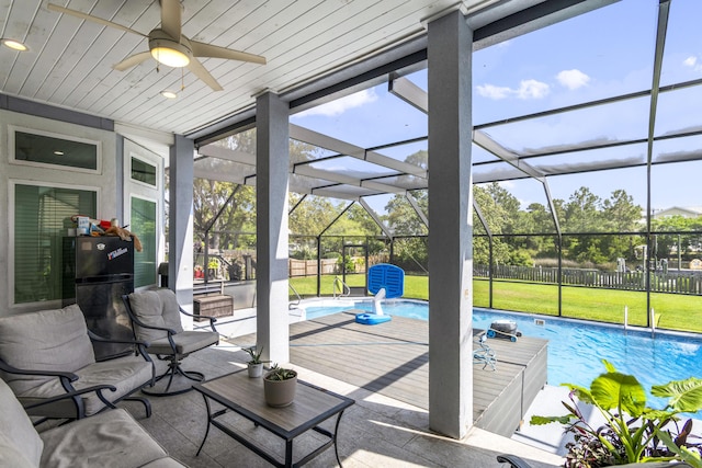 sunroom with ceiling fan, a healthy amount of sunlight, and a pool
