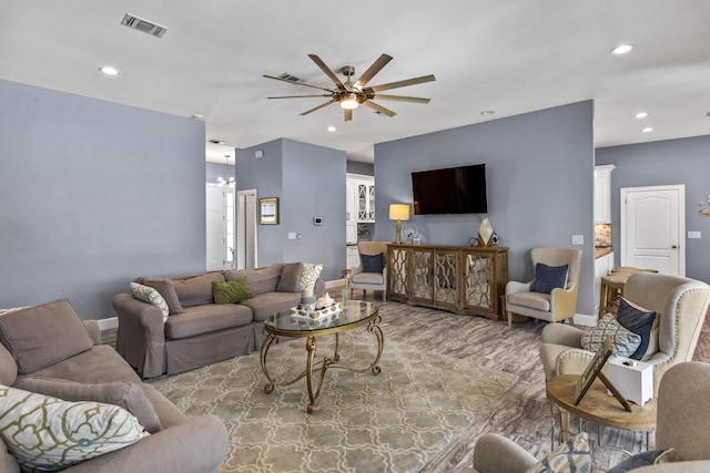 living area featuring a ceiling fan, baseboards, recessed lighting, wood finished floors, and visible vents