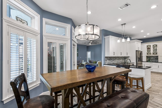 dining room with a chandelier, light wood-style flooring, recessed lighting, a healthy amount of sunlight, and visible vents