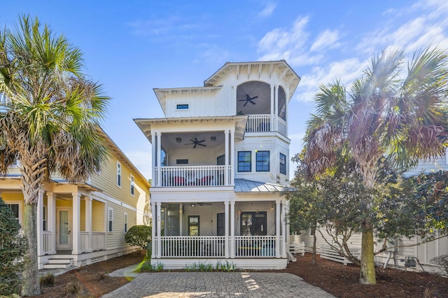 50 Cinnamon Fern Ln, Santa Rosa Beach, FL 32459 - view of front of house with a ceiling fan, a sunroom, metal roof, a balcony, and a standing seam roof