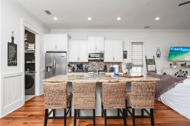 50 Cinnamon Fern Ln, Santa Rosa Beach, FL 32459 - kitchen with washer / clothes dryer, visible vents, decorative backsplash, white cabinets, and appliances with stainless steel finishes