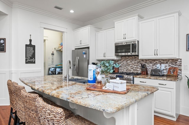 50 Cinnamon Fern Ln, Santa Rosa Beach, FL 32459 - kitchen with wood finished floors, stainless steel appliances, a kitchen breakfast bar, white cabinets, and visible vents