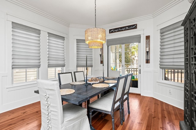50 Cinnamon Fern Ln, Santa Rosa Beach, FL 32459 - dining space with crown molding, a chandelier, a decorative wall, and wood-type flooring