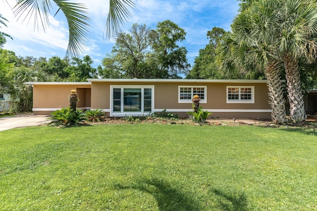 361 NE Gardner Dr, Fort Walton Beach, FL 32548 - view of front of house with stucco siding, a front lawn, and driveway