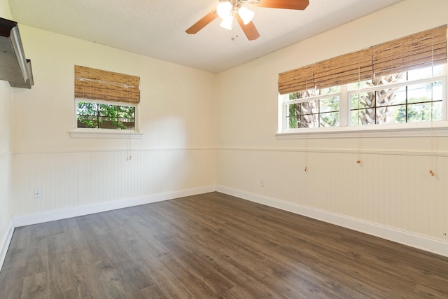 361 NE Gardner Dr, Fort Walton Beach, FL 32548 - empty room with dark wood-style flooring, a ceiling fan, plenty of natural light, and a wainscoted wall