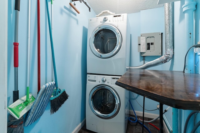 361 NE Gardner Dr, Fort Walton Beach, FL 32548 - laundry room with stacked washer and clothes dryer, electric panel, a textured ceiling, and baseboards