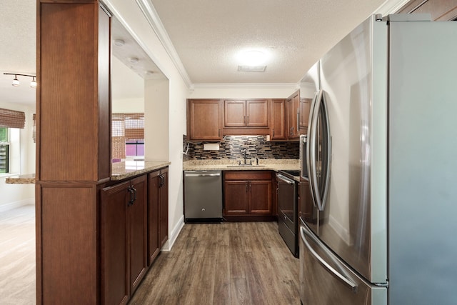 361 NE Gardner Dr, Fort Walton Beach, FL 32548 - kitchen featuring appliances with stainless steel finishes, a sink, light stone countertops, a textured ceiling, and backsplash