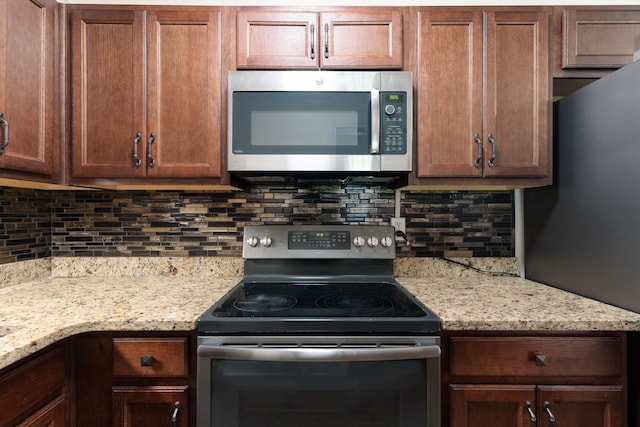 361 NE Gardner Dr, Fort Walton Beach, FL 32548 - kitchen with stainless steel appliances, backsplash, and light stone counters