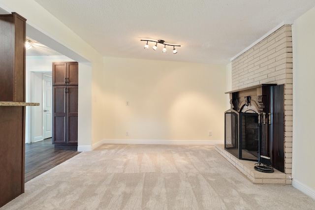 361 NE Gardner Dr, Fort Walton Beach, FL 32548 - unfurnished living room featuring a brick fireplace, carpet flooring, baseboards, and a textured ceiling