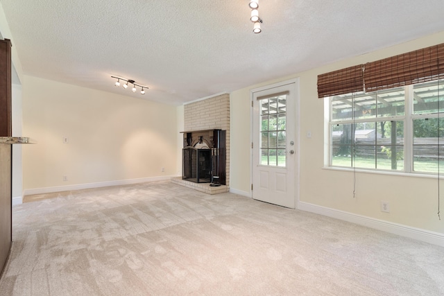 361 NE Gardner Dr, Fort Walton Beach, FL 32548 - unfurnished living room featuring light carpet, a textured ceiling, track lighting, and baseboards