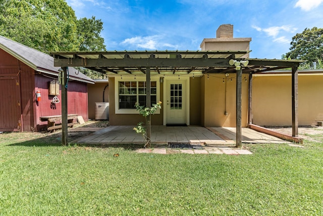 361 NE Gardner Dr, Fort Walton Beach, FL 32548 - rear view of house with a yard, stucco siding, a chimney, and an outbuilding
