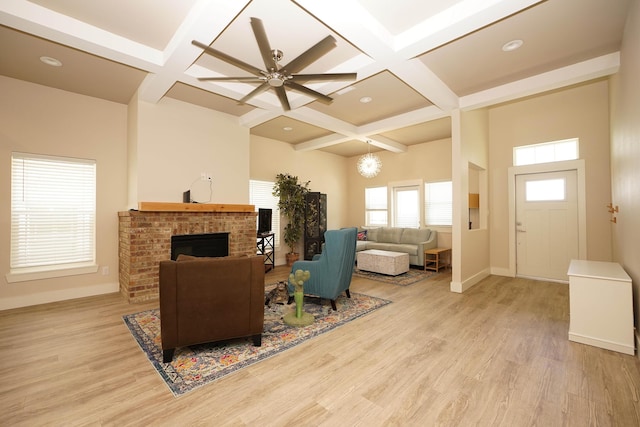 living room featuring baseboards, beam ceiling, light wood finished floors, and coffered ceiling