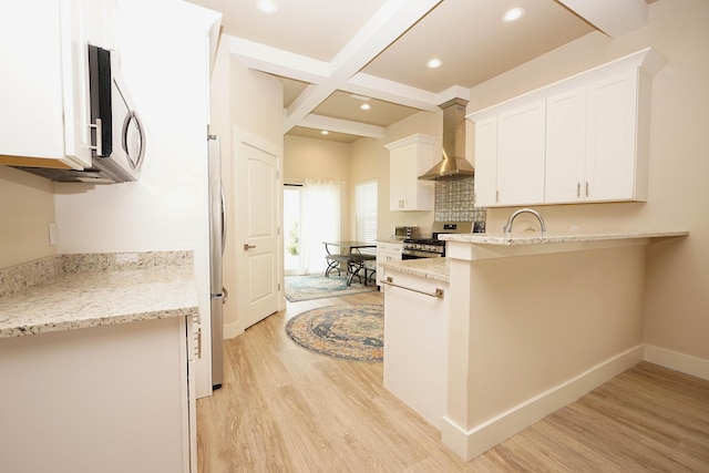 kitchen featuring beam ceiling, wall chimney exhaust hood, stainless steel appliances, light wood-type flooring, and coffered ceiling